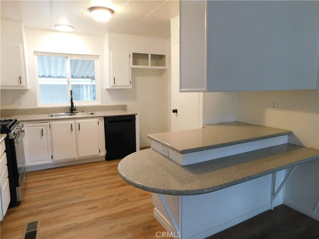 5700 West Wilson Street, Unit 1 Banning, CA 92220 - Photo 17 of 49 a kitchen with a sink cabinets and wooden floor