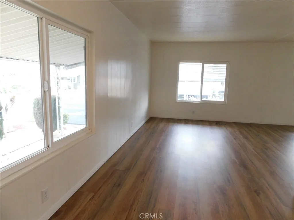 5700 West Wilson Street, Unit 1 Banning, CA 92220 - Photo 8 of 49 an empty room with wooden floor and windows