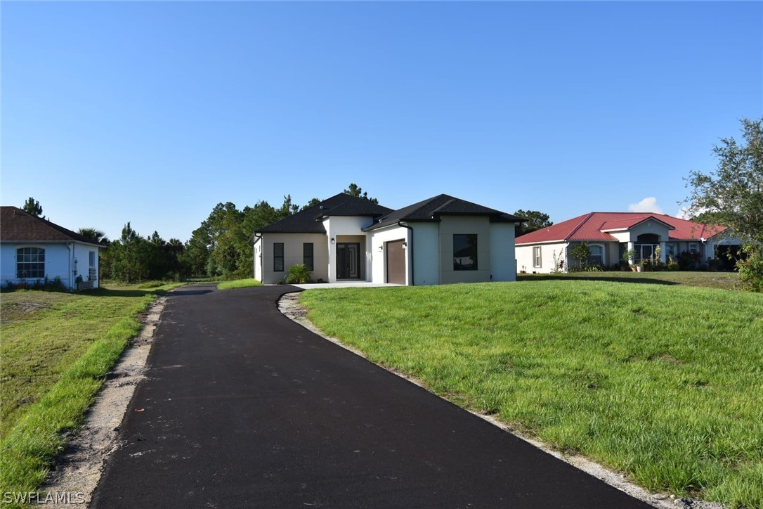 3685 Randall Boulevard Naples, FL 34120 - Photo 11 of 32 a front view of a house with garden