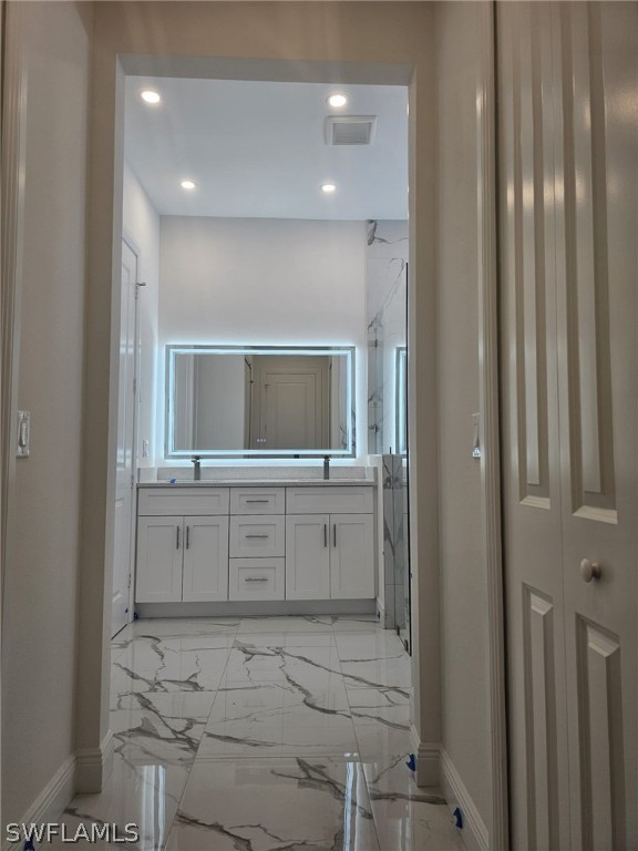 3685 Randall Boulevard Naples, FL 34120 - Photo 5 of 32 a bathroom with a sink and a mirror