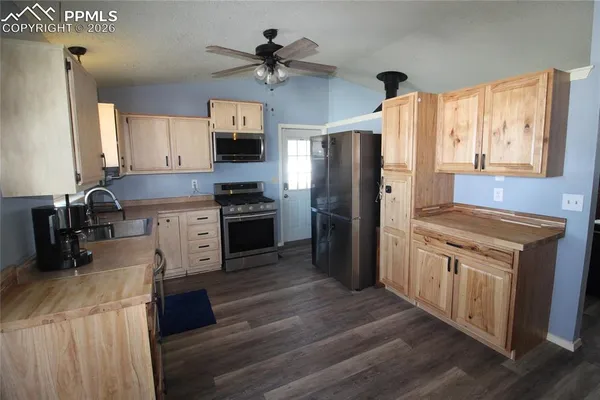 a kitchen with stainless steel appliances kitchen island granite countertop a stove a sink and a refrigerator