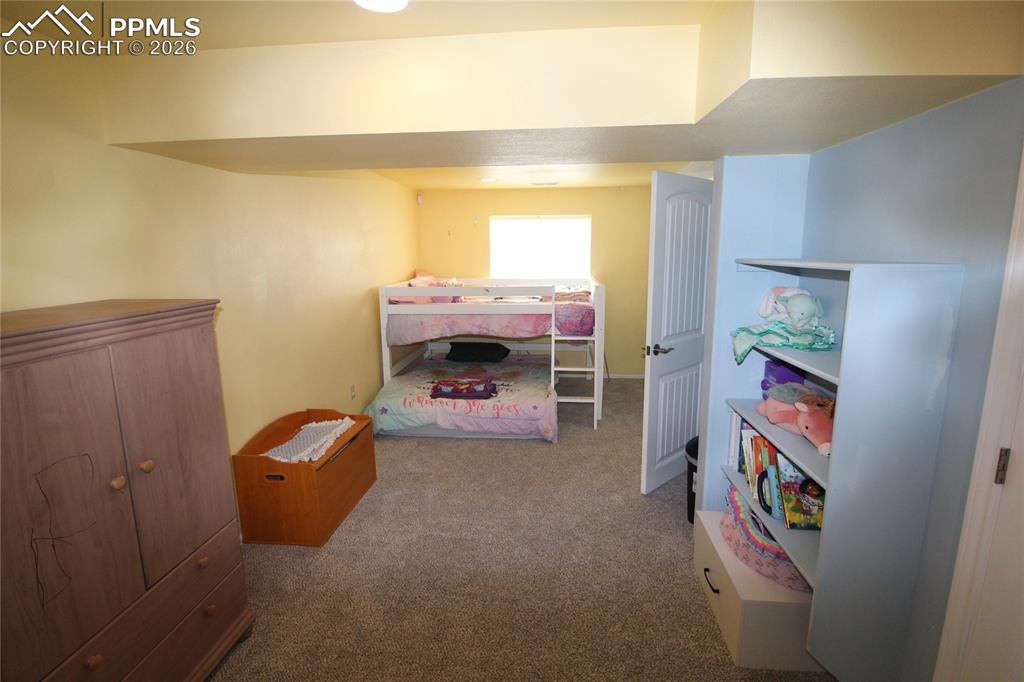 16855 Sage Crest Road Peyton, CO 80831 - Photo 20 of 27 a room with a baby crib and a couch