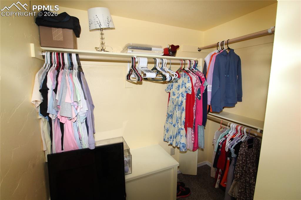 16855 Sage Crest Road Peyton, CO 80831 - Photo 23 of 27 a view of walk in closet with clothes and shoes
