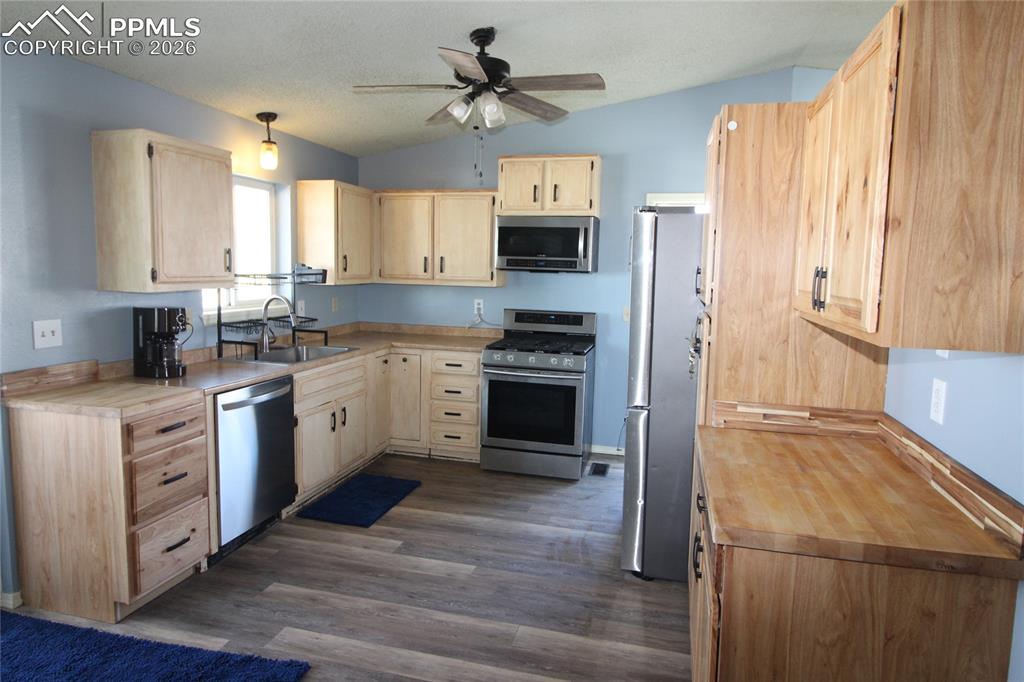 16855 Sage Crest Road Peyton, CO 80831 - Photo 4 of 27 a kitchen with a stove a sink and a refrigerator