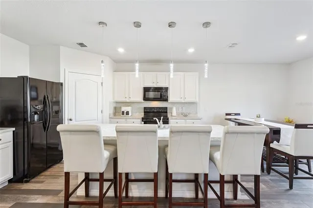a kitchen with kitchen island white cabinets and stainless steel appliances