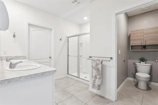 a bathroom with a granite countertop sink a toilet and a shower