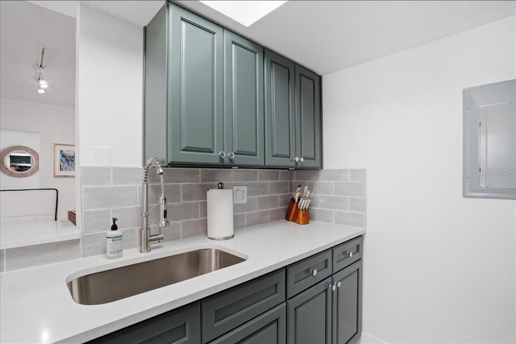 8911 Blind Pass Road, Unit 118 St. Pete Beach, FL 33706 - Photo 17 of 34 a kitchen with a sink and cabinets