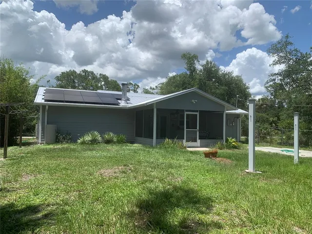 a backyard of a house with table and chairs