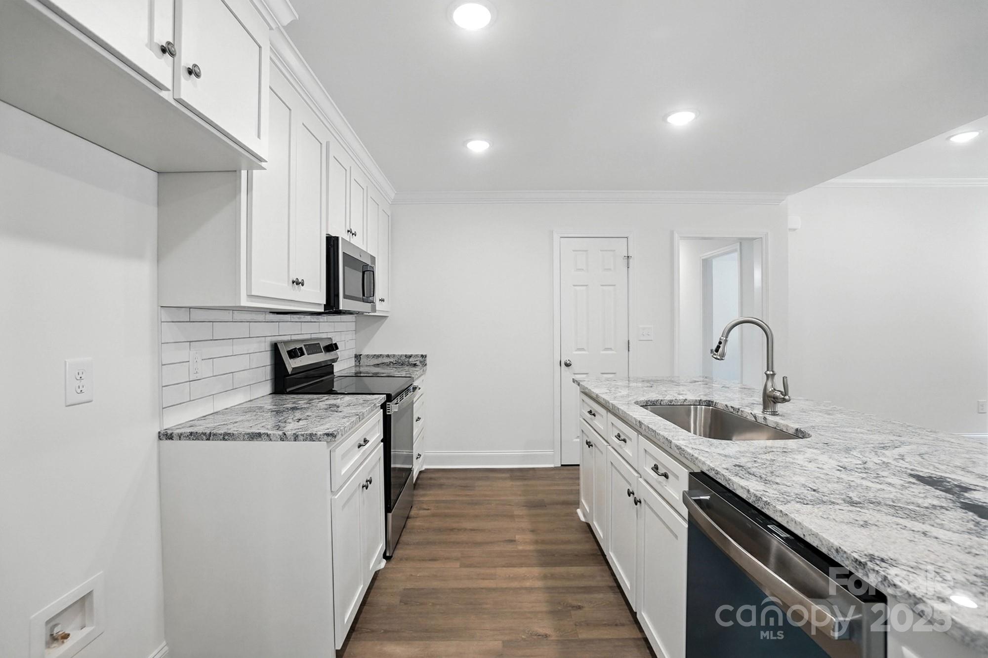 233 Lincoln Road York, SC 29745 - Photo 12 of 37 a large kitchen with stainless steel appliances granite countertop a lot of counter space and wooden floors