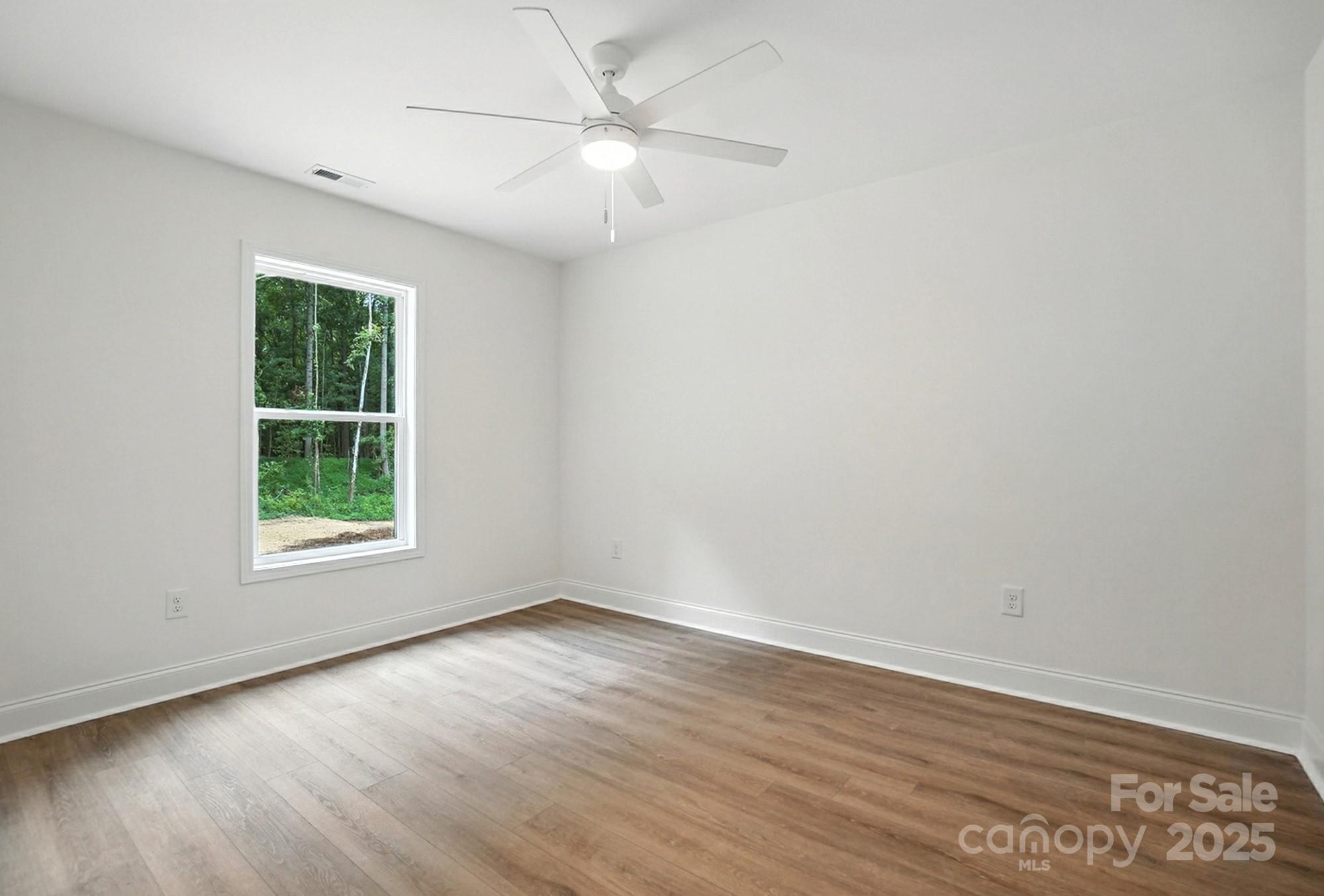 233 Lincoln Road York, SC 29745 - Photo 28 of 37 an empty room with wooden floor chandelier fan and windows