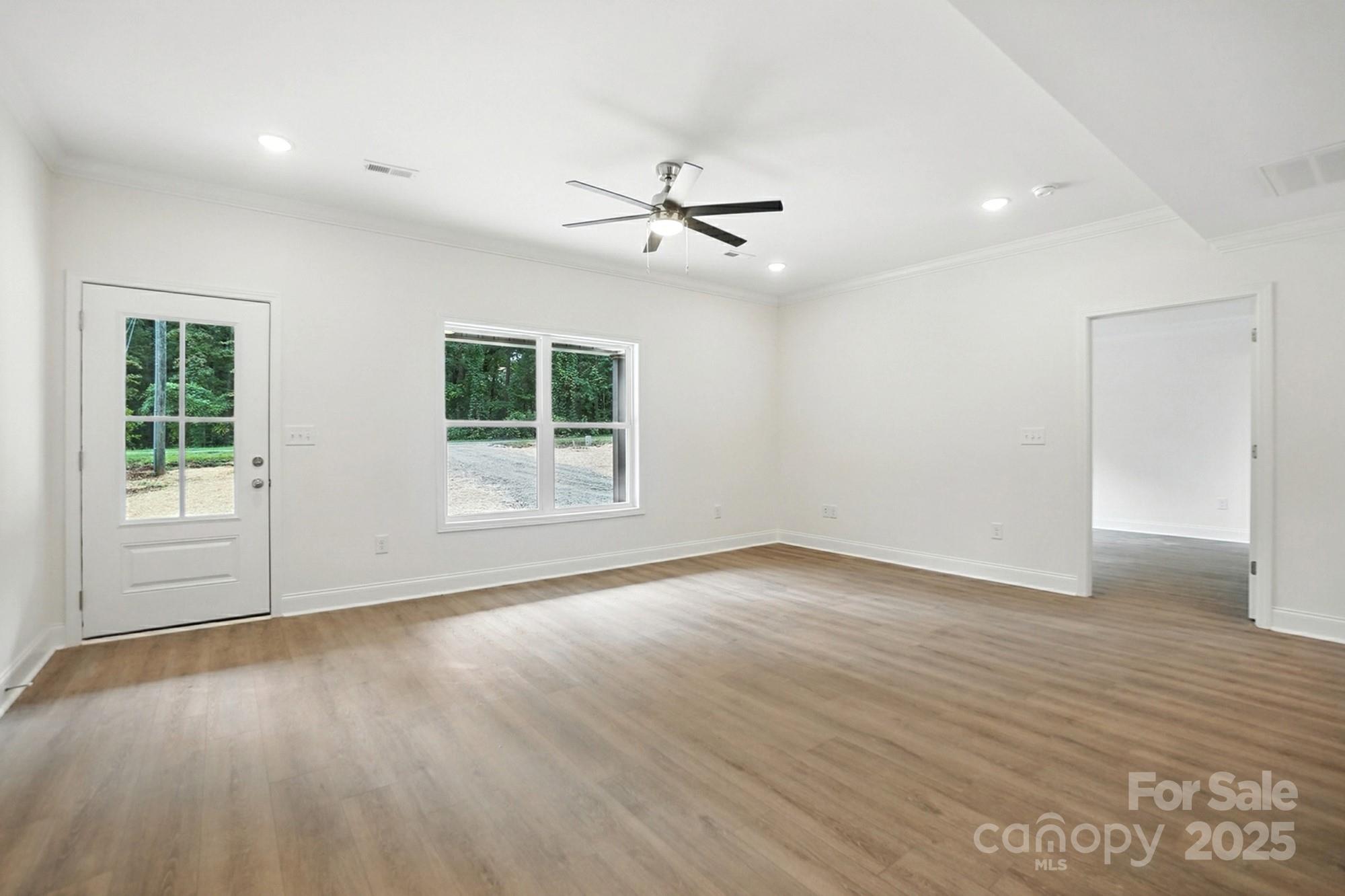 233 Lincoln Road York, SC 29745 - Photo 6 of 37 an empty room with wooden floor ceiling fan and windows