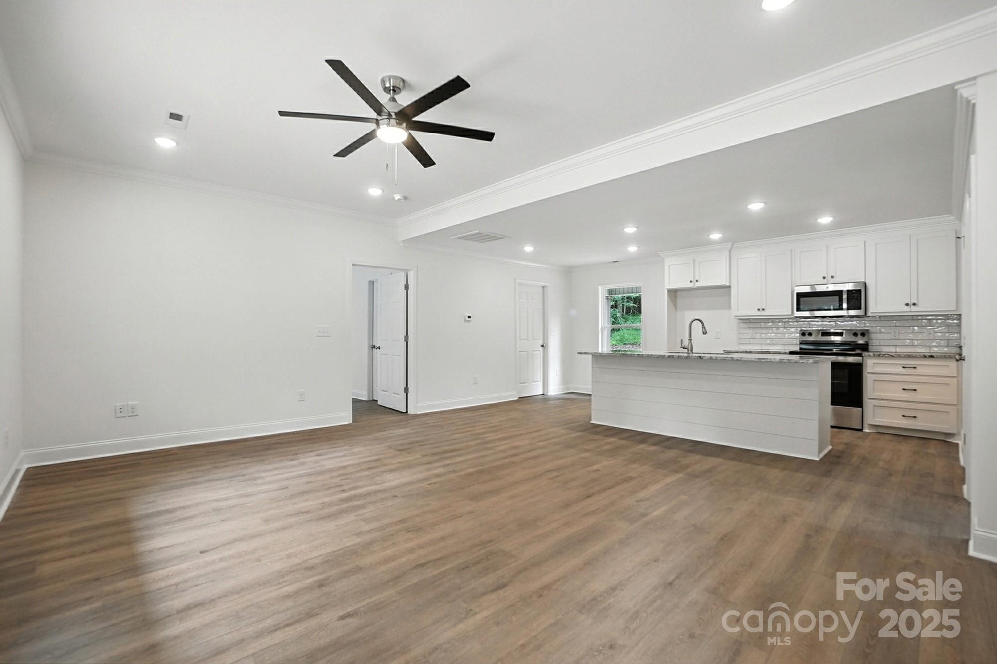 233 Lincoln Road York, SC 29745 - Photo 7 of 37 a view of an empty room with kitchen appliances and a ceiling fan