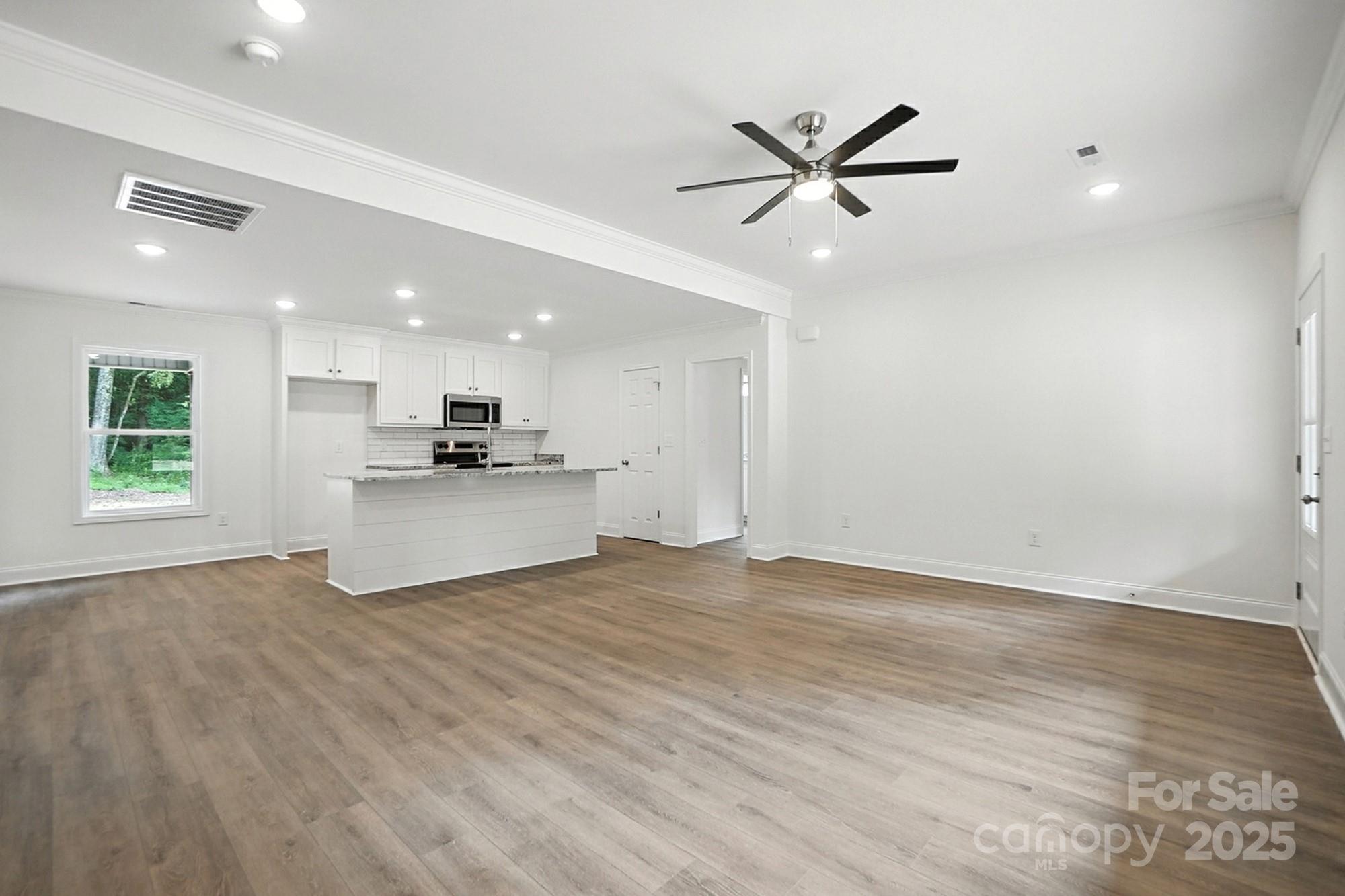 233 Lincoln Road York, SC 29745 - Photo 8 of 37 a view of a kitchen with a sink a ceiling fan and wooden floor