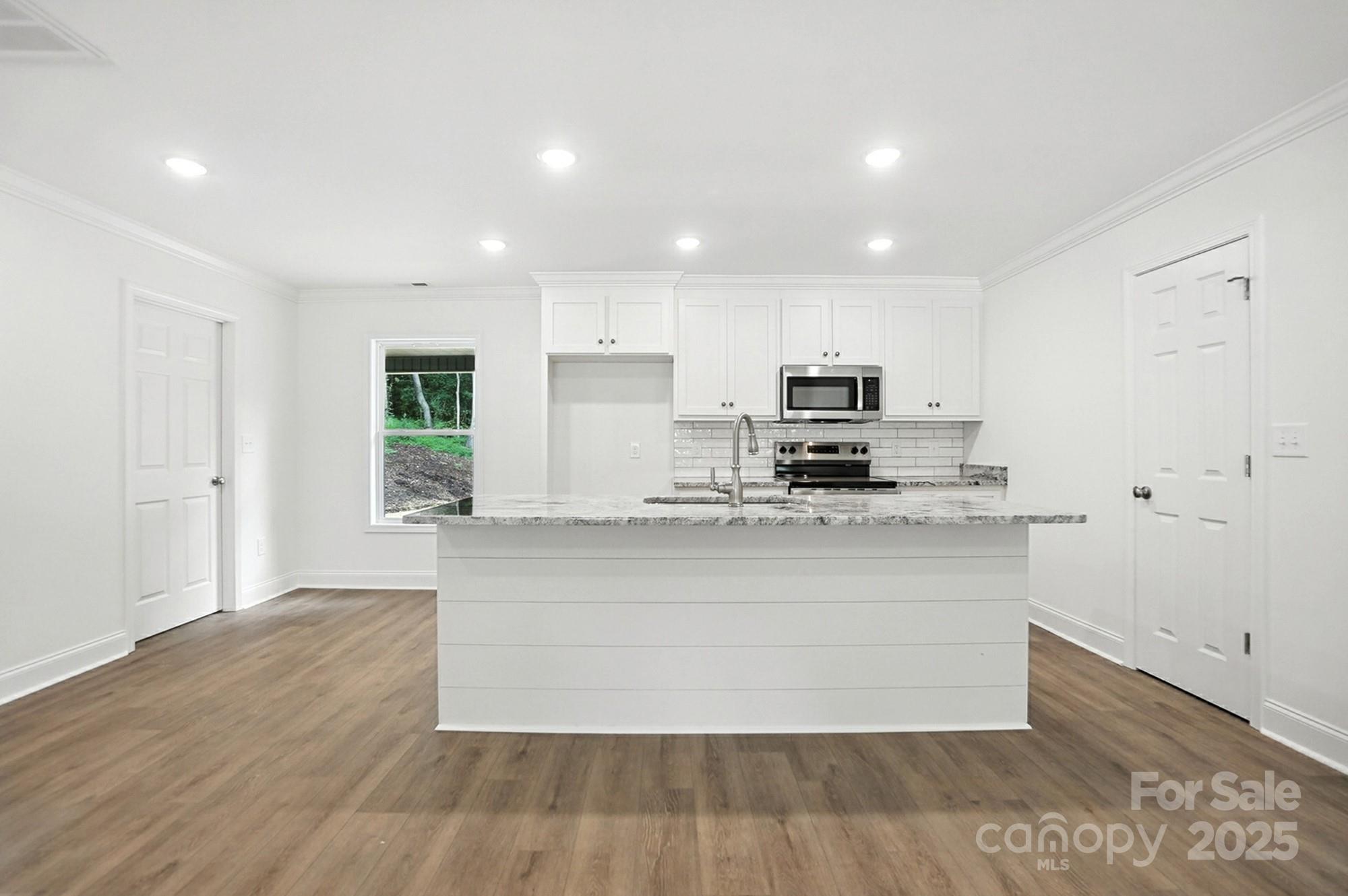 233 Lincoln Road York, SC 29745 - Photo 9 of 37 a large kitchen with stainless steel appliances a large counter top a stove and a refrigerator