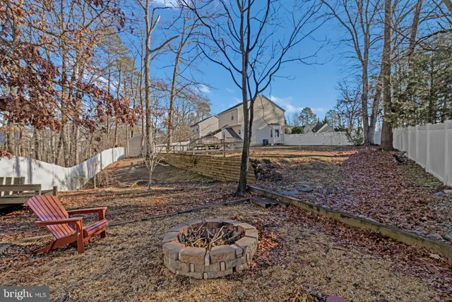 a view of a backyard with chair and fire pit