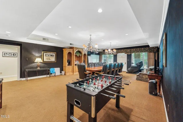 a spacious bedroom with a bed a chandelier and large window