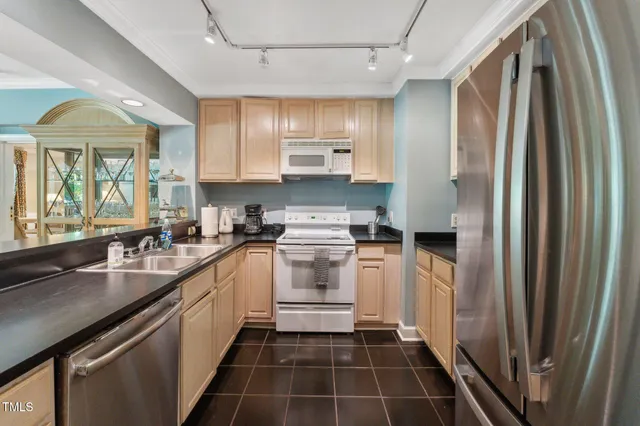 a kitchen with stainless steel appliances a stove a sink and a refrigerator