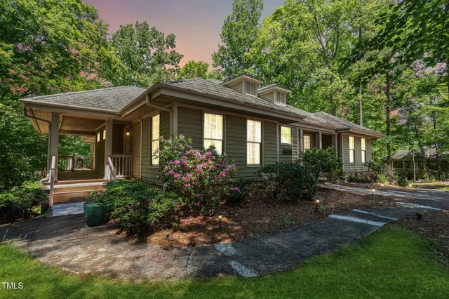 a front view of house with yard and trees around