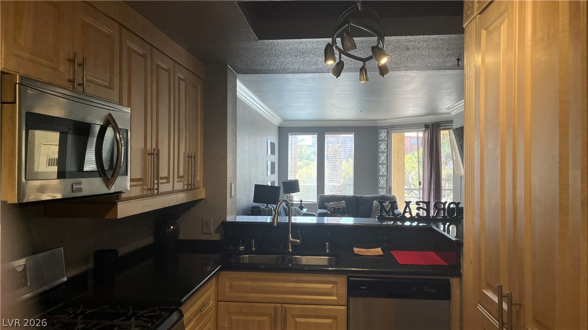 210 East Flamingo Road, Unit 205 Las Vegas, NV 89169 - Photo 5 of 17 A well-appointed kitchen featuring sleek stainless steel appliances and abundant cabinetry, overlooking the living space.