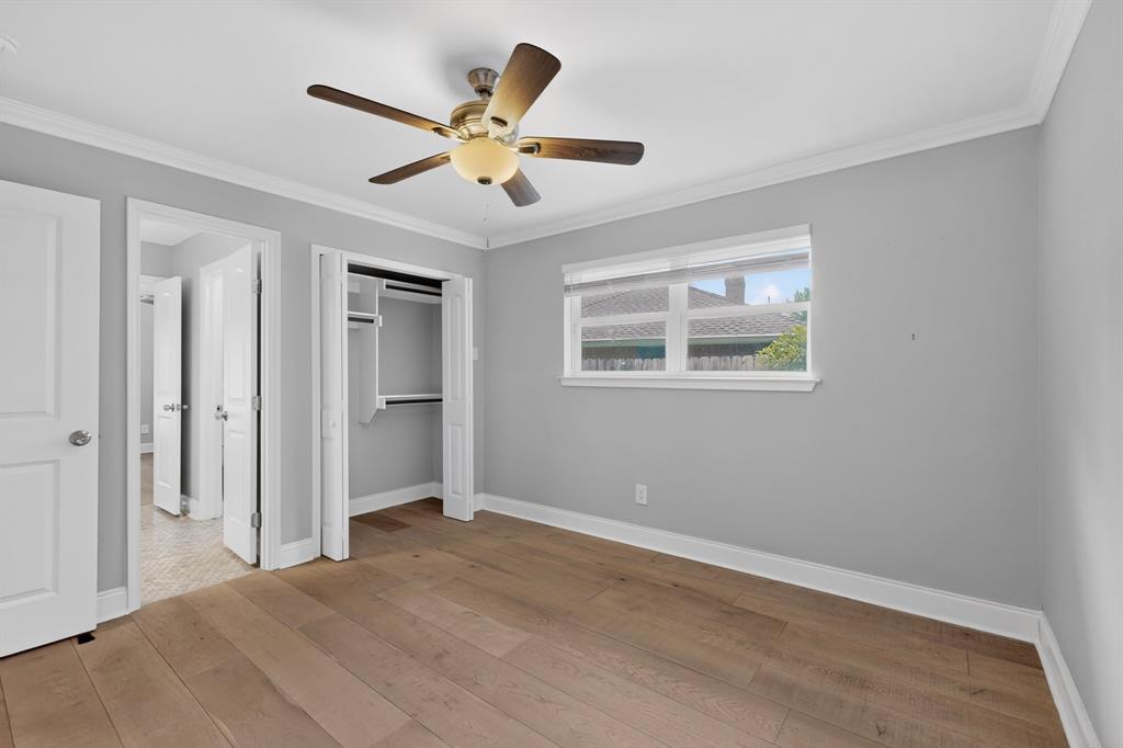 7631 Meadow Road Dallas, TX 75230 - Photo 20 of 40 A bright bedroom with a ceiling fan, a wide window and a closet