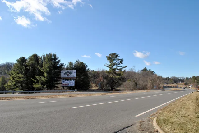 a view of a house with a yard and a car park
