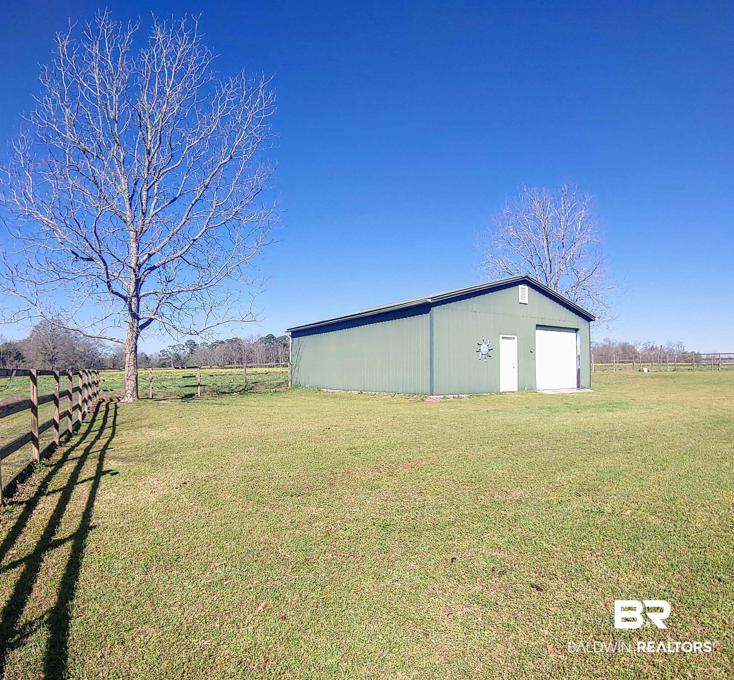 770 Arena Road Frisco City, AL 36445 - Photo 45 of 51 Exterior space featuring a rural view, an outbuilding, fence, and a pole building