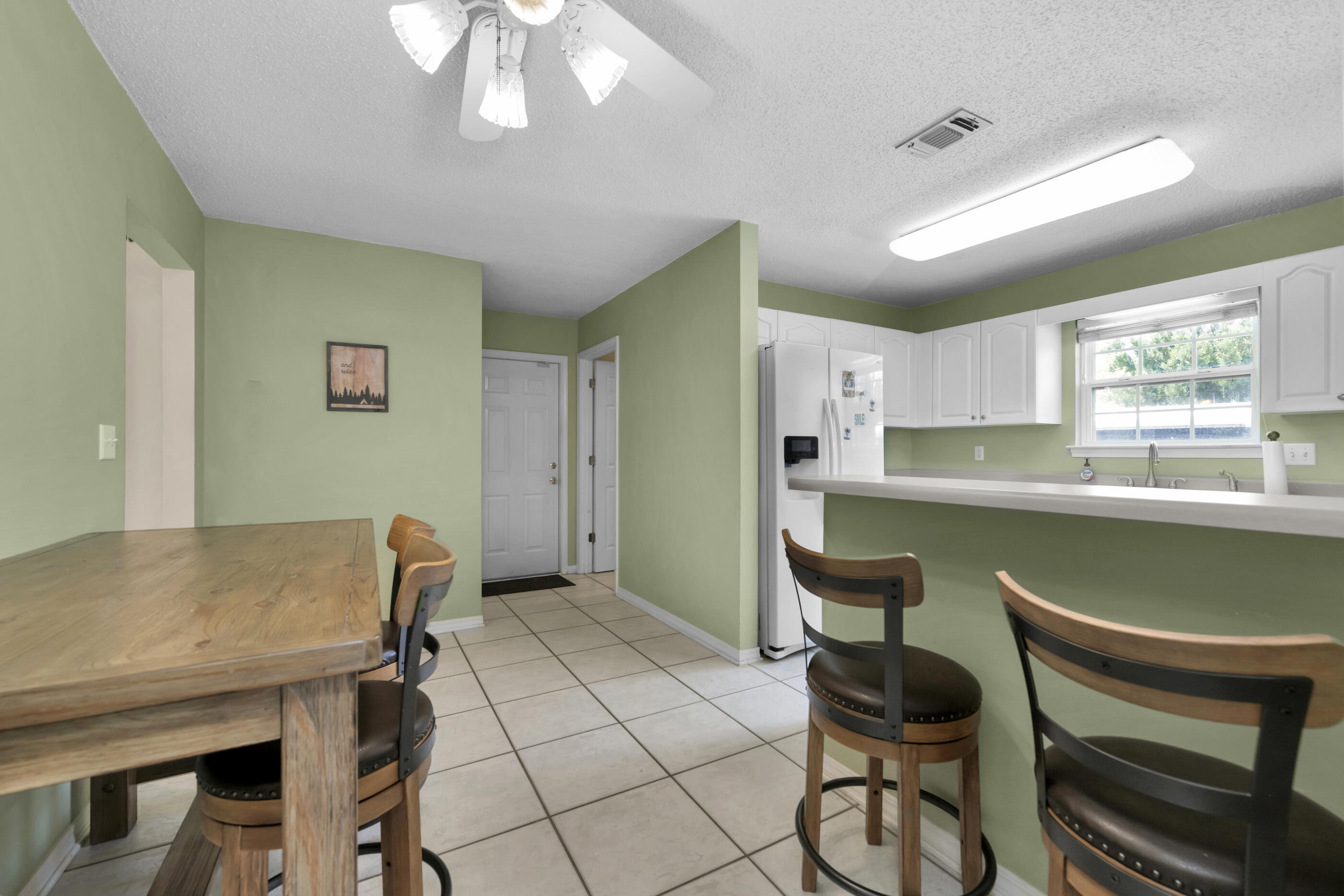 738 Riva Ridge Drive Crestview, FL 32539 - Photo 9 of 23 a kitchen with a table chairs and a refrigerator