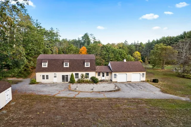 a view of a house with a yard and a large tree
