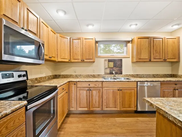 a kitchen with stainless steel appliances granite countertop a stove a sink and a microwave