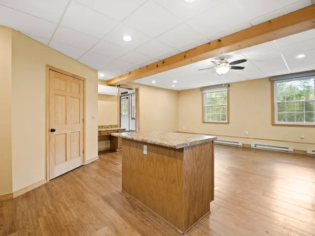 a view of a kitchen with a sink and dishwasher with wooden floor