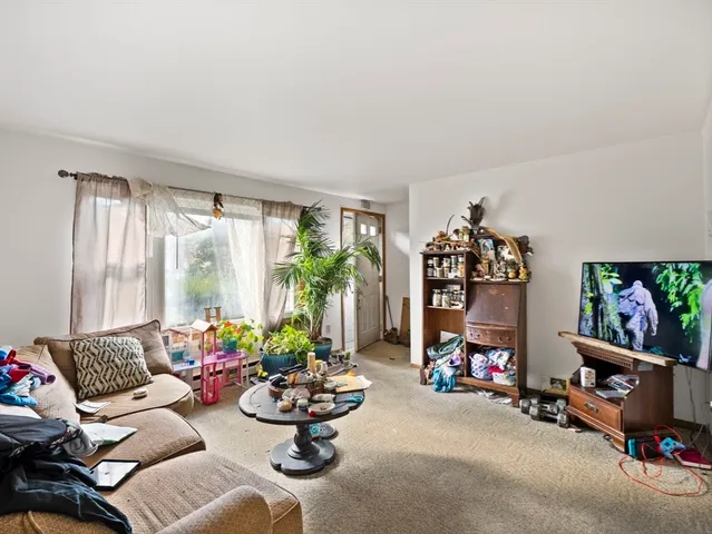 a living room with furniture toys and a flat screen tv