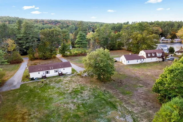 an aerial view of residential house with outdoor space and trees all around