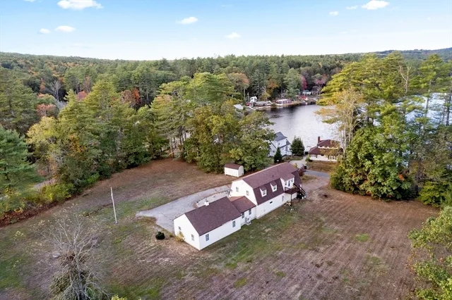 an aerial view of a house with a yard and lake view
