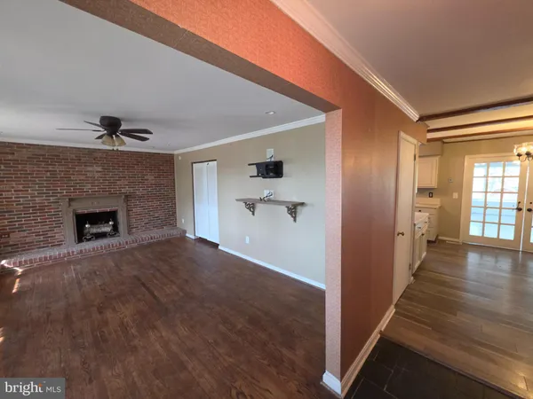 a view of a hallway with wooden floor and a fireplace