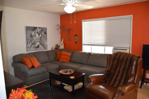 a living room with furniture a couch and paintings on the wall