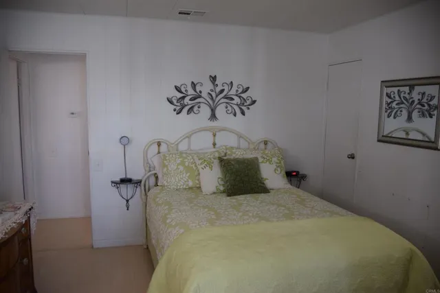 a bed sitting in a bedroom next to a bathroom