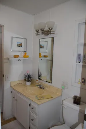 a bathroom with a granite countertop sink a toilet and a mirror