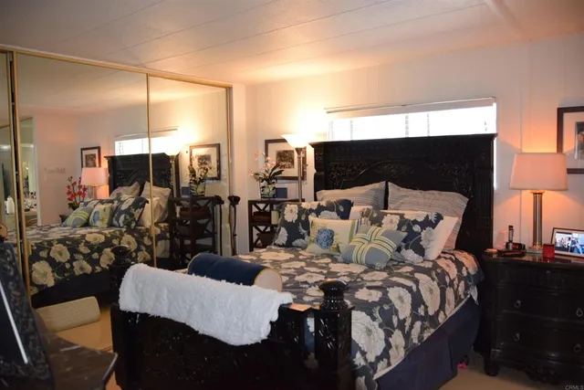 a bedroom with a bed a mirror and lamp