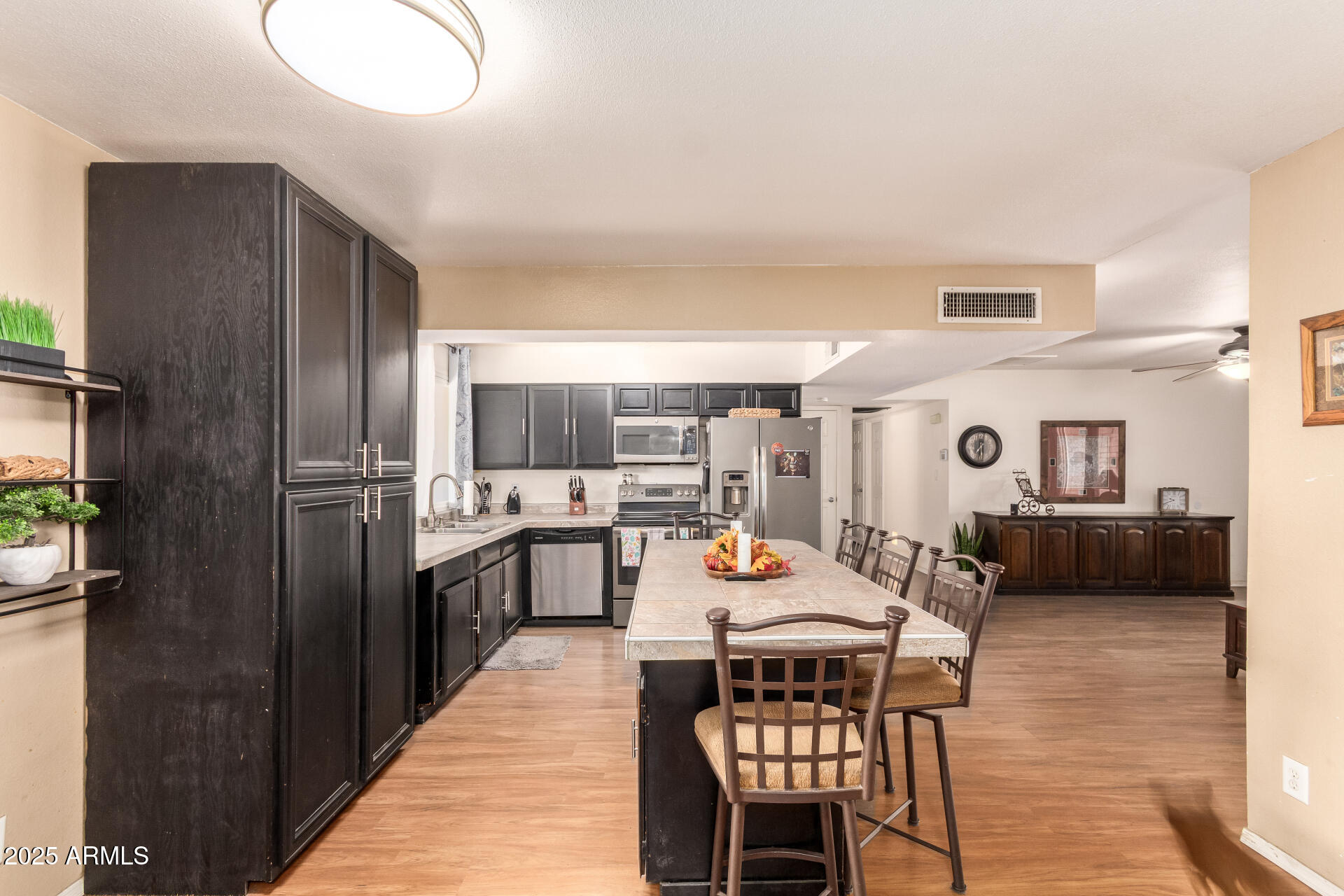 3341 West Pershing Avenue Phoenix, AZ 85029 - Photo 17 of 36 a kitchen with stainless steel appliances a dining table chairs and a refrigerator