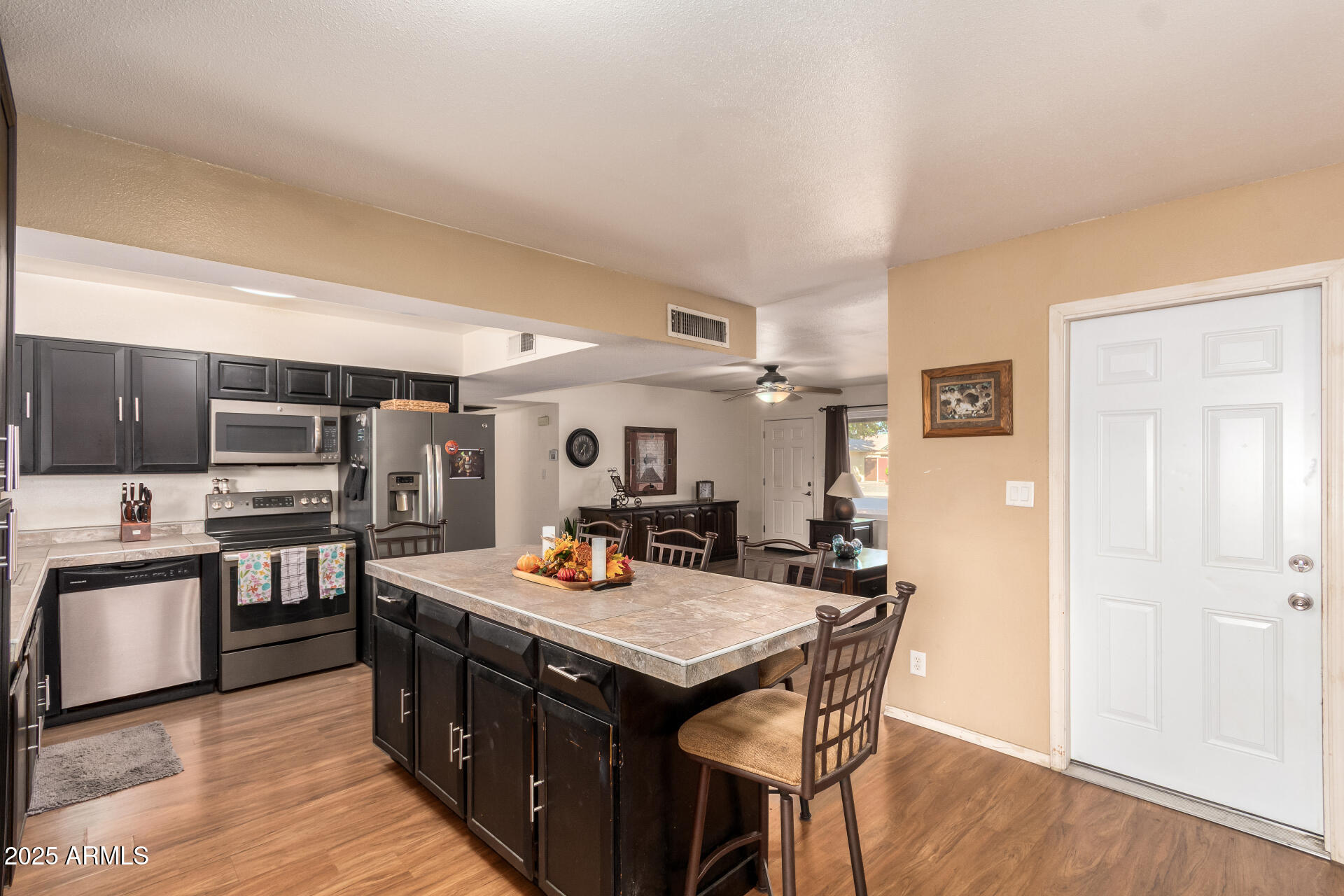 3341 West Pershing Avenue Phoenix, AZ 85029 - Photo 18 of 36 a kitchen with stainless steel appliances kitchen island granite countertop a stove a sink dishwasher and a refrigerator with wooden floor