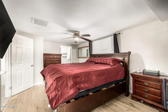 a bedroom with a bed and wooden floor
