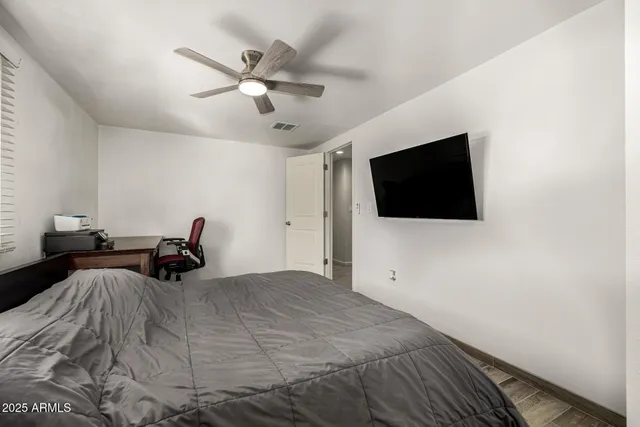 a bedroom with a bed window and a flat screen tv