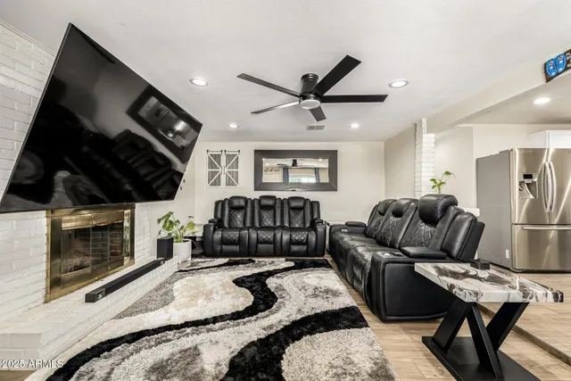 a living room with furniture ceiling fan and a fireplace