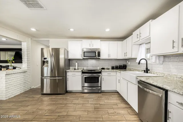 a kitchen with stainless steel appliances granite countertop a refrigerator sink and microwave