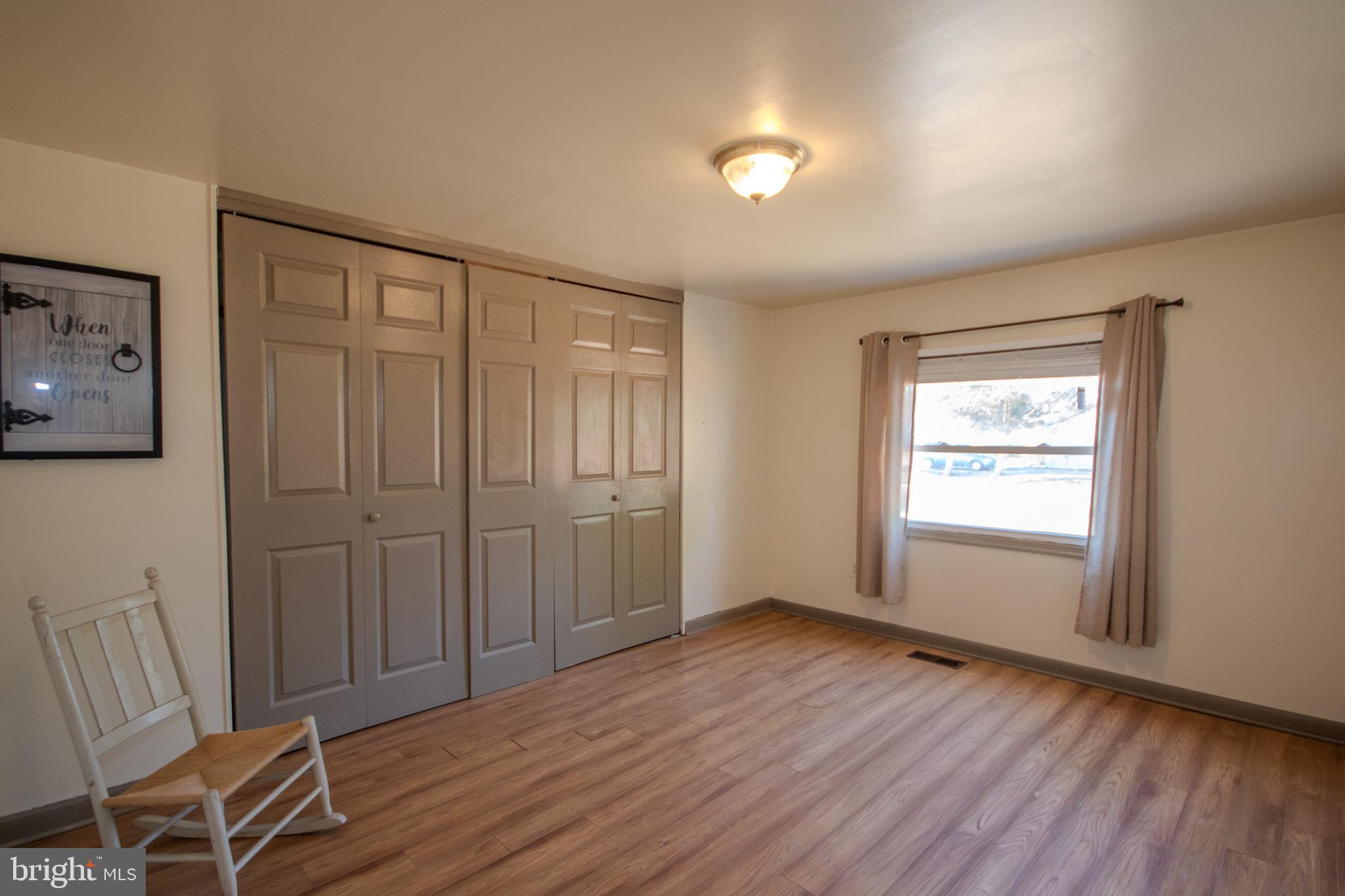 6761 Sharptown Road Laurel, DE 19956 - Photo 15 of 34 an empty room with wooden floor and windows