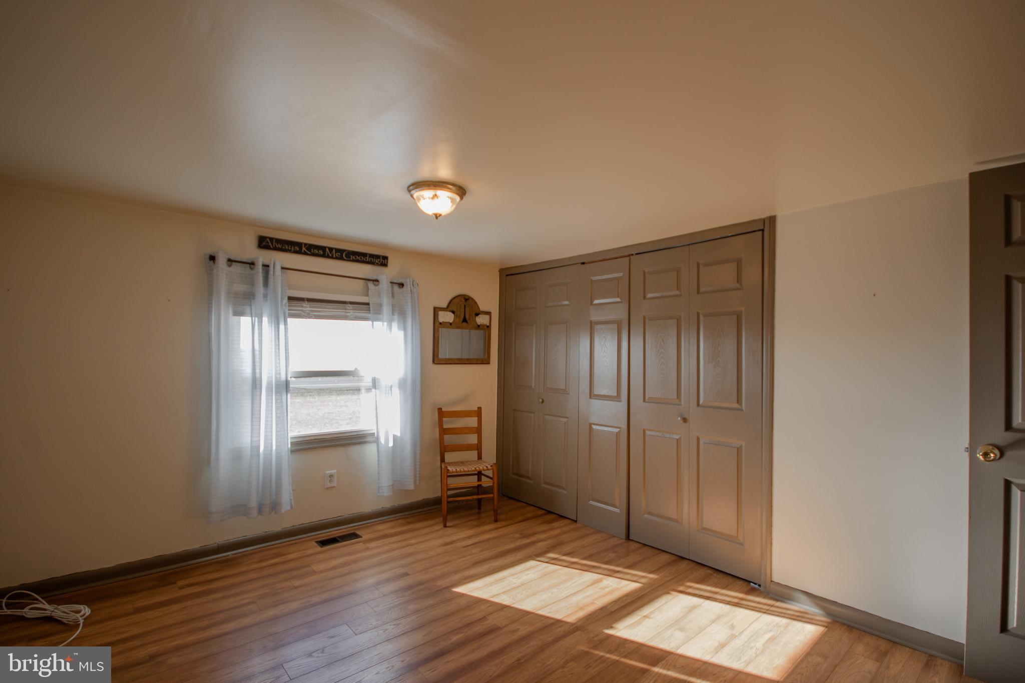 6761 Sharptown Road Laurel, DE 19956 - Photo 19 of 34 an empty room with wooden floor closet and windows