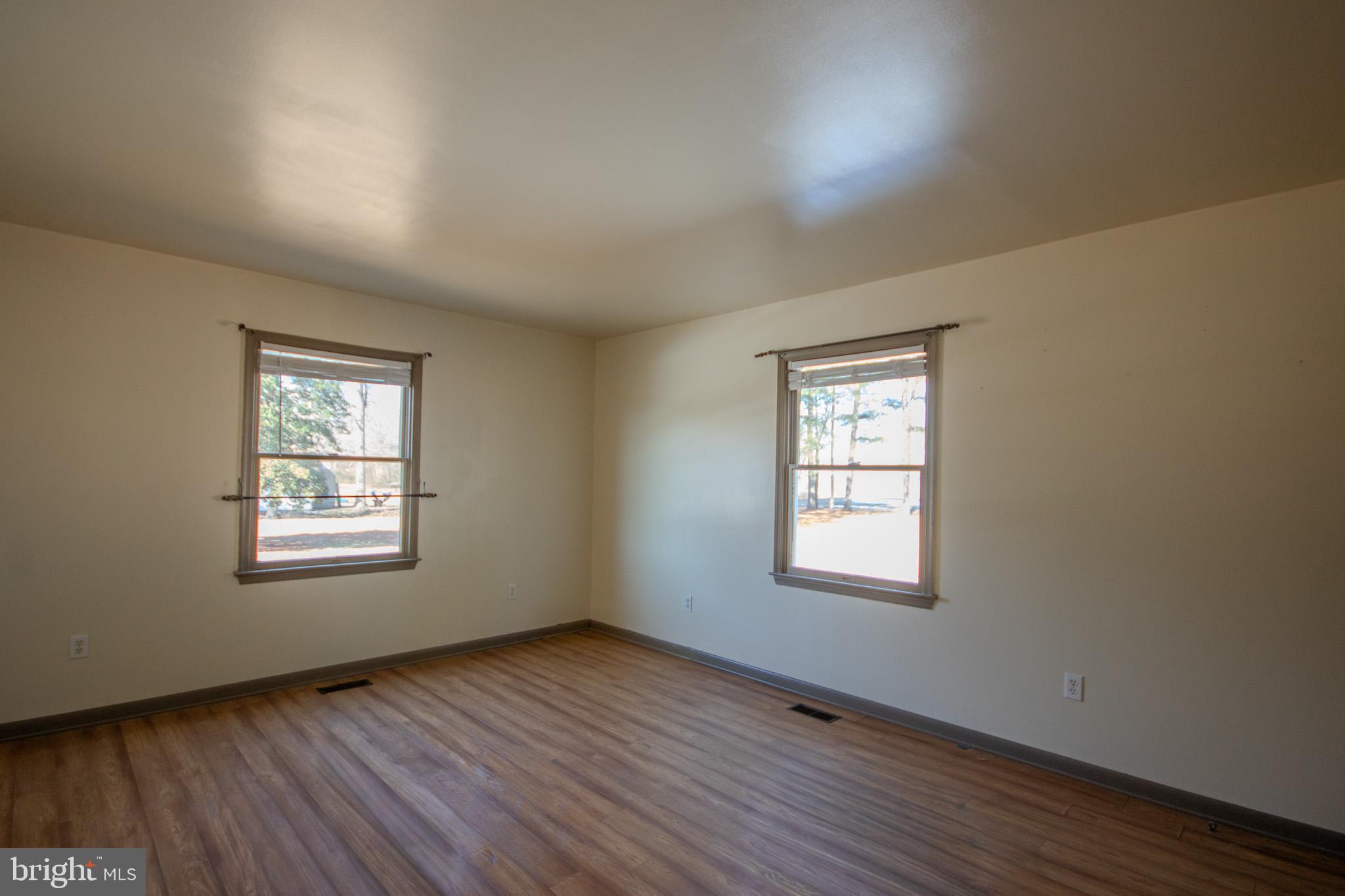 6761 Sharptown Road Laurel, DE 19956 - Photo 21 of 34 an empty room with wooden floor and windows