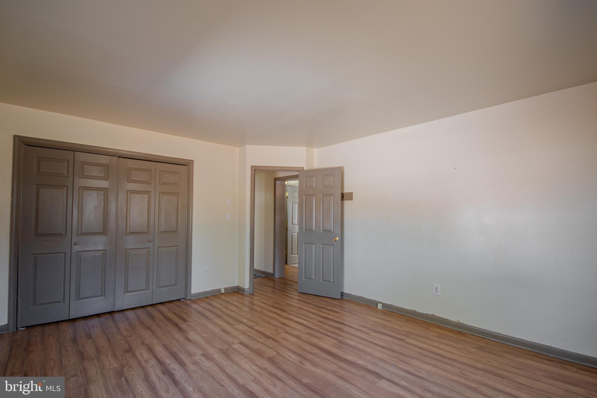 6761 Sharptown Road Laurel, DE 19956 - Photo 22 of 34 an empty room with wooden floor and closet area