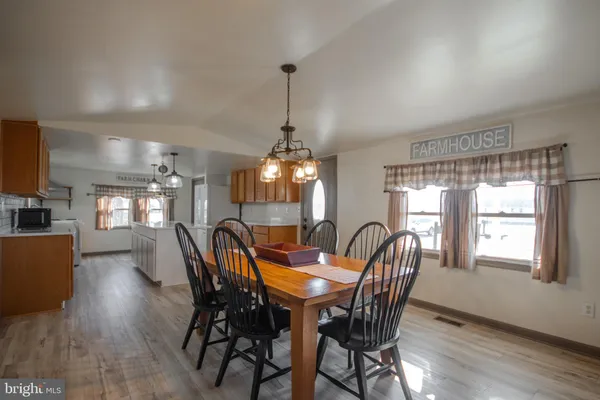 a dining room with furniture a chandelier and wooden floor