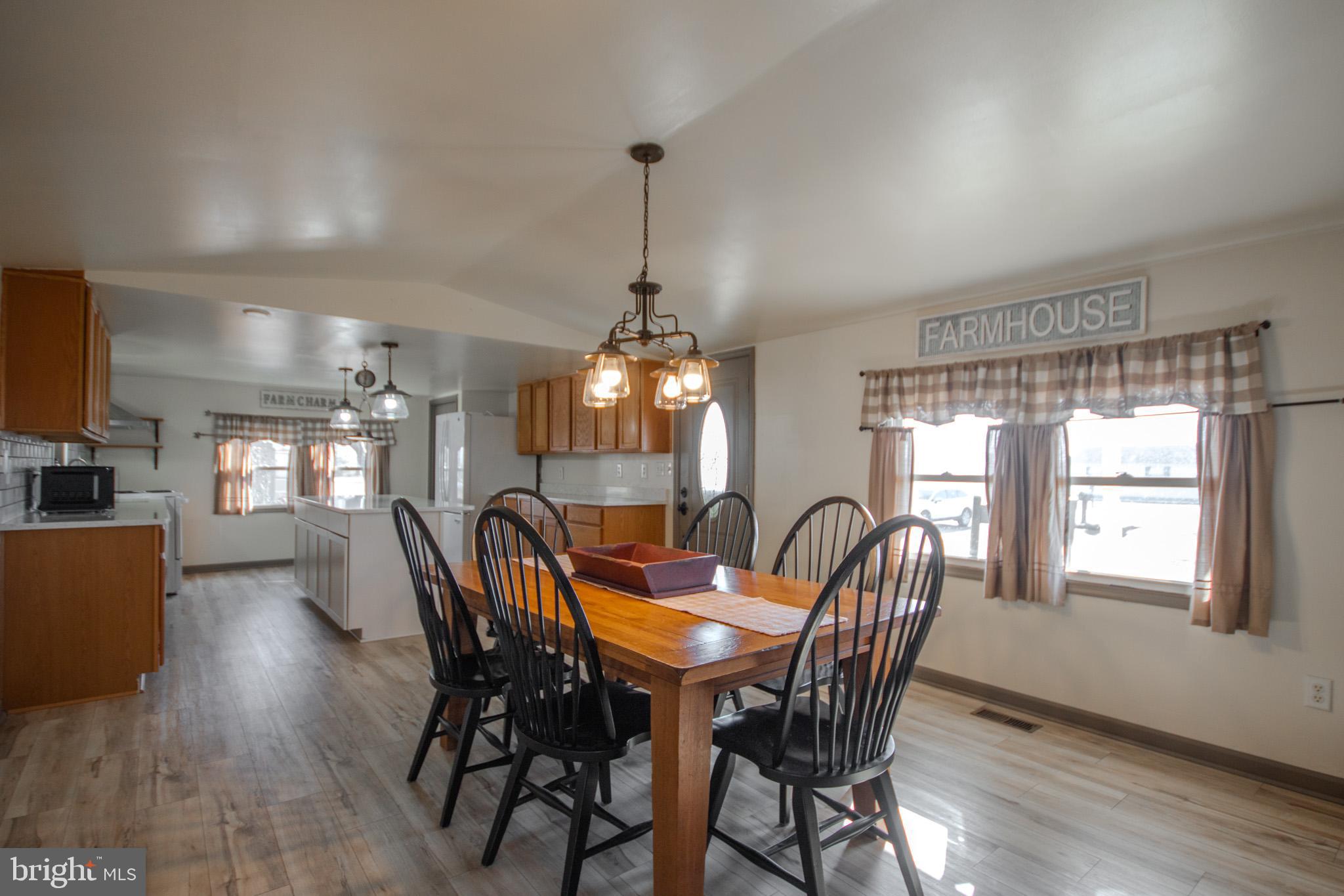 6761 Sharptown Road Laurel, DE 19956 - Photo 8 of 34 a dining room with furniture a chandelier and wooden floor